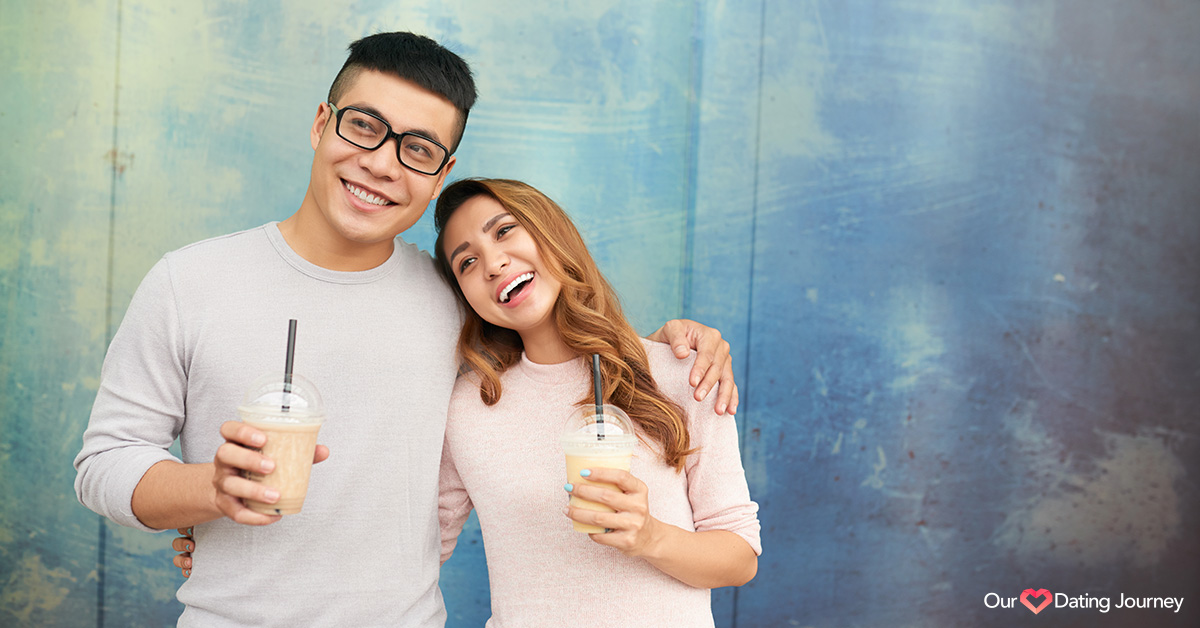 Happy Asian couple holding drinks