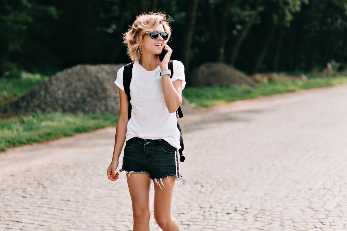 Young woman walking and talking over the phone outside