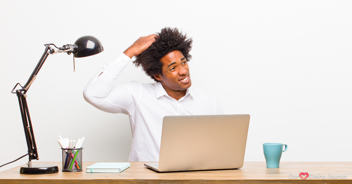 Young black man scratching head while at desk